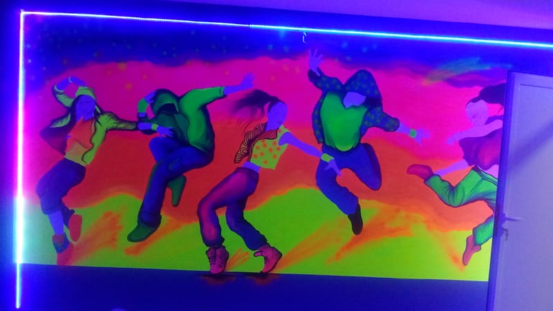 Zidni crtež sa plesačima u fluorescentnim bojama, osvetljen UV svetlom i led trakom