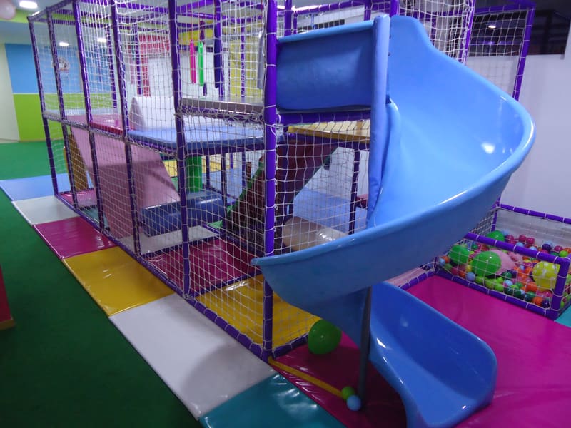 Spiralni tobogan u prvom planu i konstrukcija lavirinta sa zaštitnim mrežama