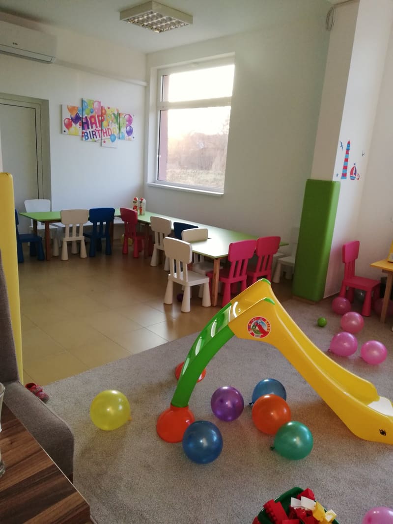 Deo igraonice u Čačku sa stolovima i stolicama za decu i tapaciranom oblogom stuba