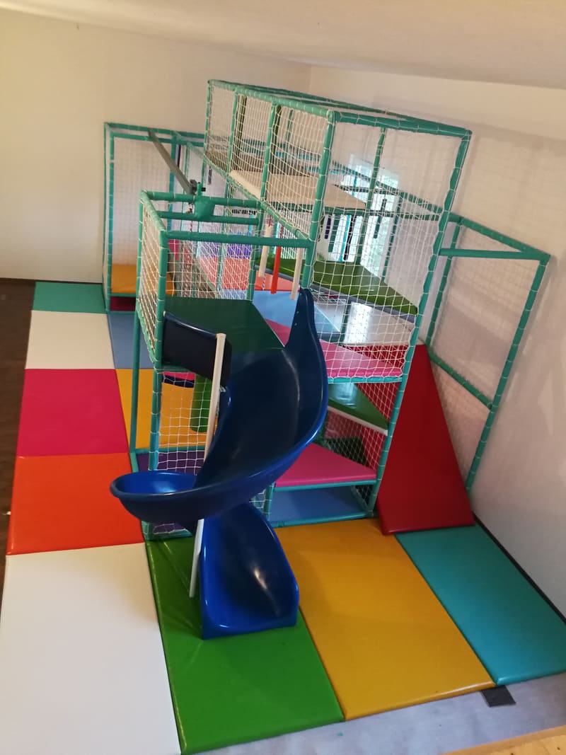 Ceo lavirint snimljen odozgo — spiralni tobogan, crvena rampa i šarene podne obloge