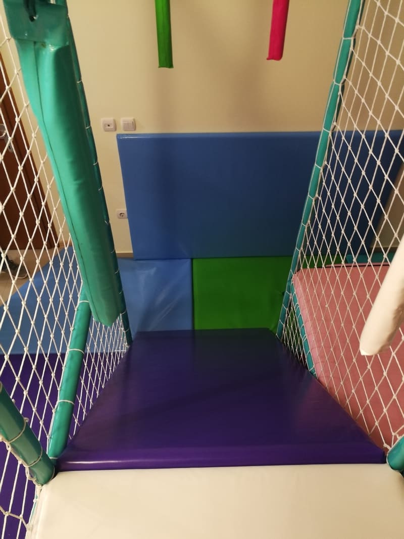 Ugao lavirinta sa ljubičastom podlogom i tapaciranim zidom u plavoj i zelenoj boji