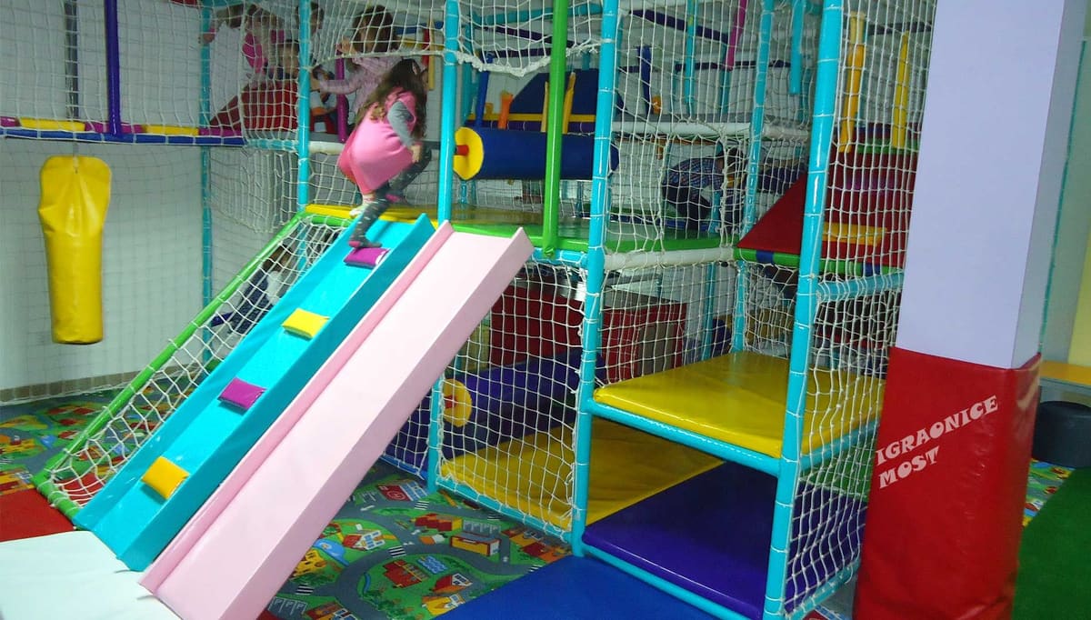 Plavi tobogan iz lavirinta sa strunjačama i zelenom podlogom