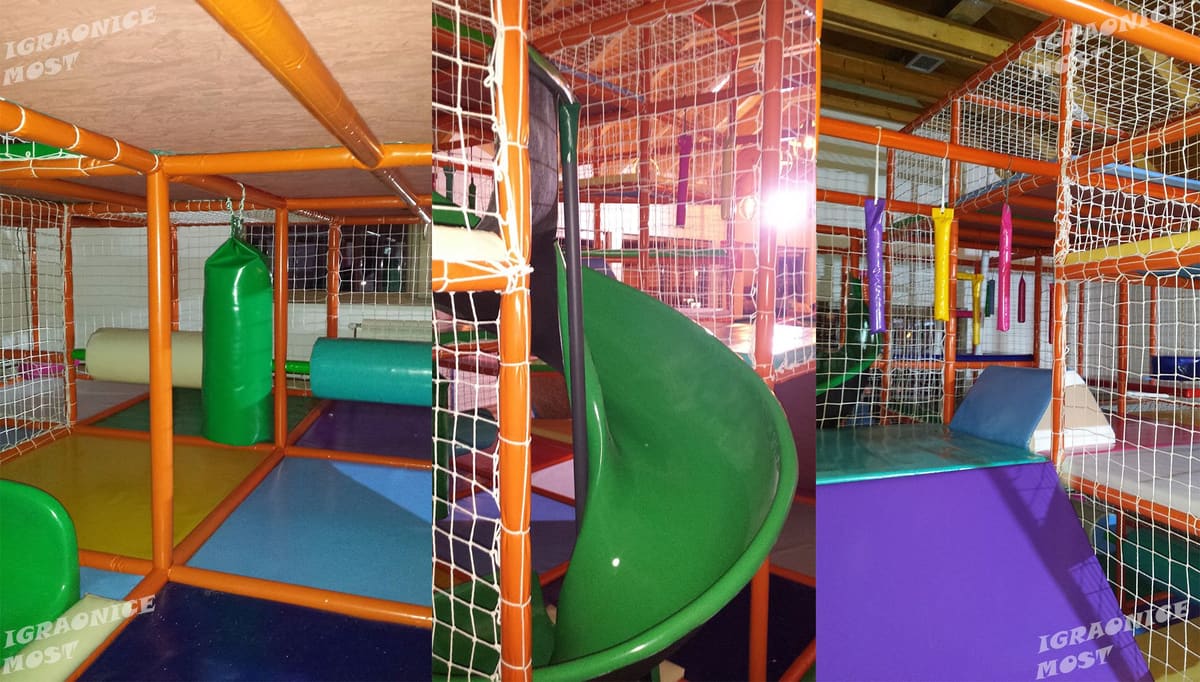 Zeleni tobogan i narandžasta konstrukcija lavirinta u dečijoj igraonici