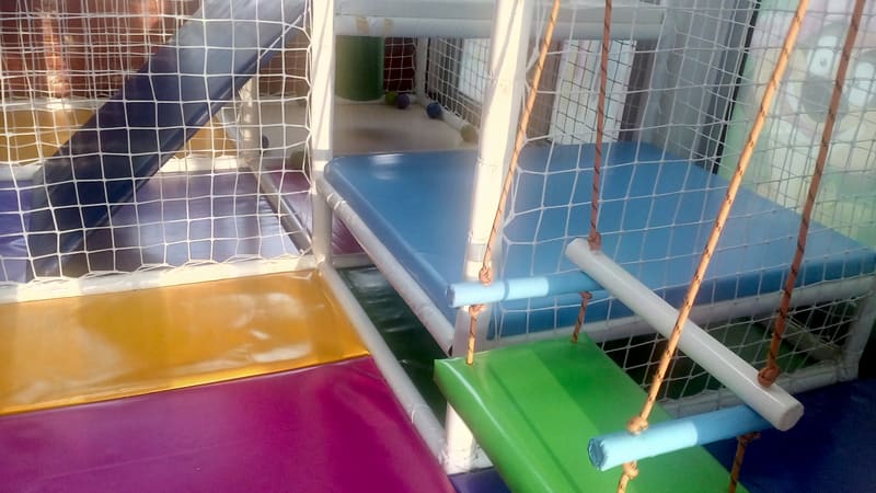 Ljuljaška sa zelenim sedištem na užadima unutar lavirinta