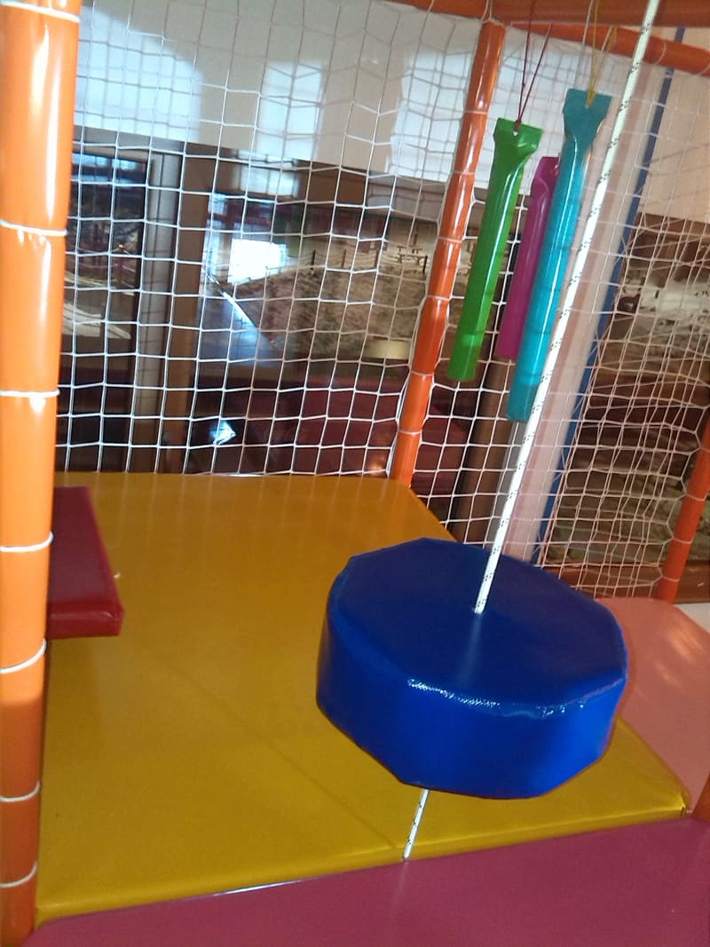 Ljuljaška sa okruglim sedištem na užetu iznad žute podloge